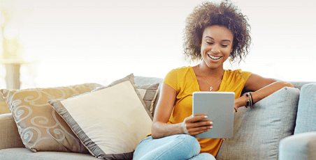 person on couch using tablet